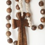 a wooden cross hanging from a white wall